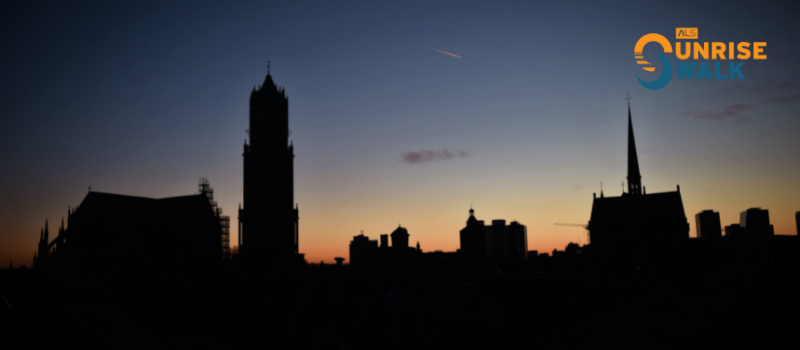 Zonsopgang boven Utrecht met het logo van de ALS Sunrise Walk in de rechterbovenhoek