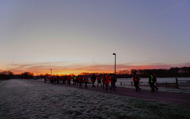 wandelaars lopen de zonsopgang tegemoet tijdens de ALS Sunrise Walk in Utrecht