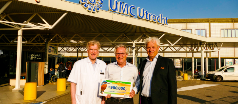 Michiel Scheeren, deelnemende patiënt aan Tricals, Leonard van den Berg, coördinator ALS Centrum en Gorrit-Jan Blonk, directeur Stichting ALS Nederland, staan voor het UMC Utrecht met de cheque van 9 ton van de Nationale Postcode Loterij.