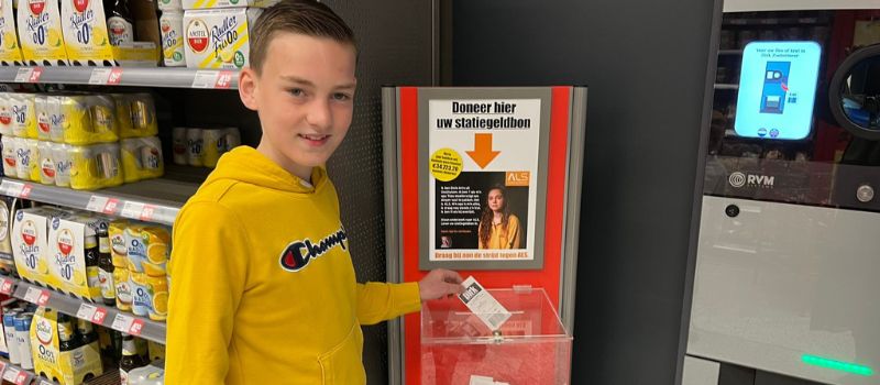 Jeugdambassadeur Sam Vreugdenhil doneert een statiegeldbonnetje bij supermarktketen Dirk van den Broek.